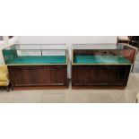 A pair of mahogany veneered shop counter display cabinets, one drop-down door missing and damage