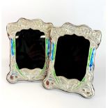 A pair of sterling silver Art Nouveau style wooden backed photograph frames, H. 21cm, W. 16cm.