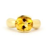 A heavy 18ct yellow gold (stamped 18K) solitaire ring set with a large oval cut citrine, stone