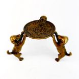 A small Chinese bronze stand of three puppies holding a coin, H. 4cm, W. 8cm.