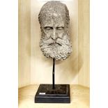 An antique cast concrete face of an elderly man on a metal stand, overall H. 63cm.