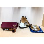 A brass tobacco box with a reproduction meerschaum style pipe and a further pipe.