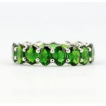 A 925 silver full eternity ring set with oval cut chrome diopside, approx. 8.14ct total, (O). With