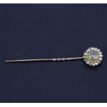 A yellow metal (tested minimum 9ct gold) stick pin set with a round cabochon opal surrounded by