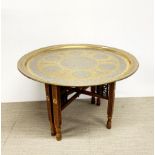 A heavy quality silver decorated Eastern brass coffee table with folding wooden base, Dia. 67cm,