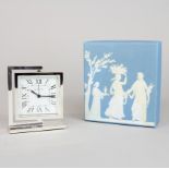 A white metal mounted Wedgwood clock with box, H. 12cm, W. 10cm.