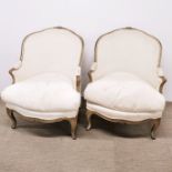 A pair of cream upholstered French lounge armchairs, H. 87cm. Stains to fabric.