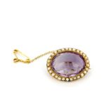 An antique 9ct yellow gold (stamped 9ct) brooch set with a faceted amethyst and seed pearls, with