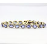 A stunning 925 silver bracelet set with oval cut tanzanites and diamonds with a 9ct yellow gold