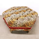 An interesting tiger print upholstered and buttoned footstool with castors and tassel edges, 105 x
