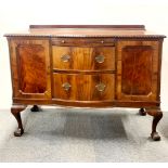 A 20th Century partially bow fronted, two drawer mahogany sideboard with ball and claw feet, 134 x