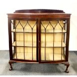 A bow front, two shelf stained mahogany display cabinet with ball and claw feet, 130 x 120 x 35cm.