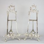 A pair of silvered brass easels, H. 53cm, W. 26cm.