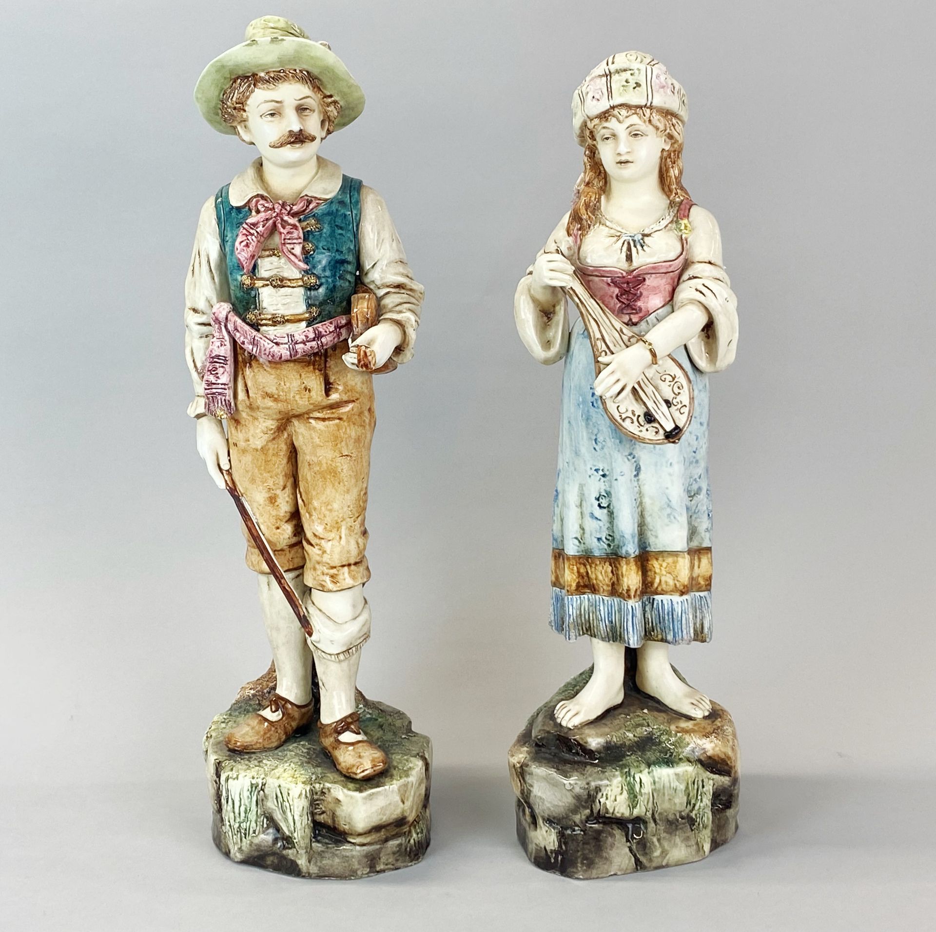 A pair of Austrian glazed pottery figures of musicians c.1900, H. 40cm. Girl A/F to top of lute.