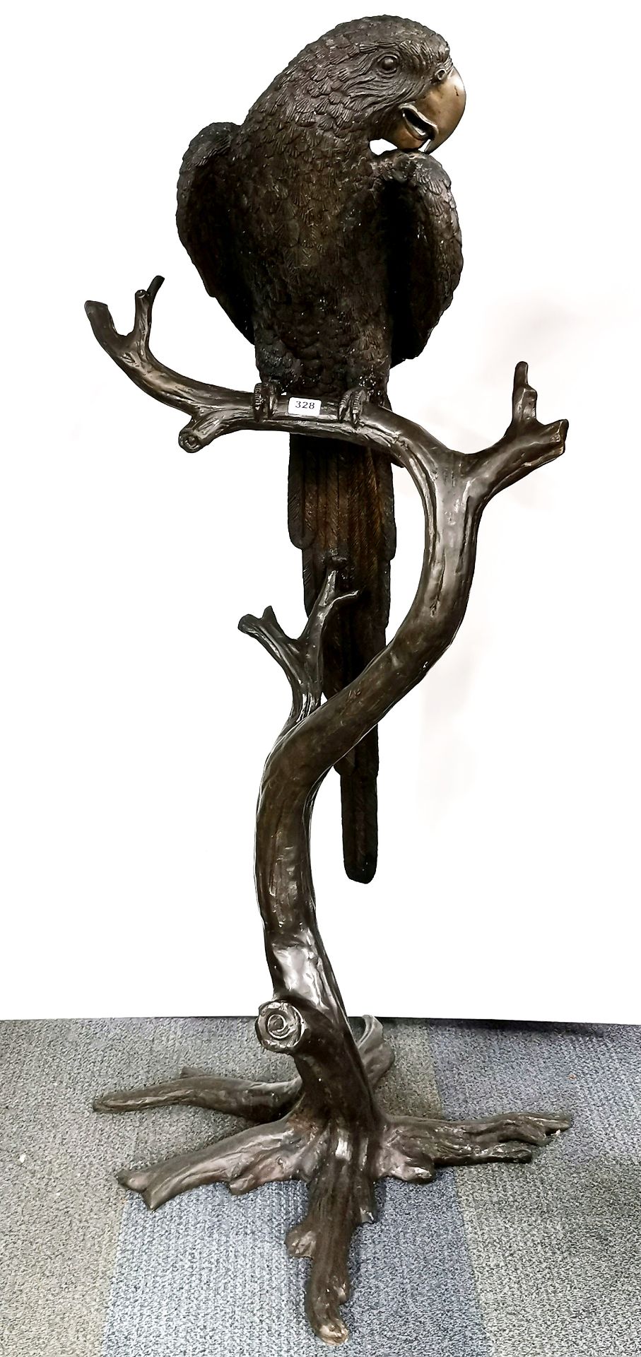 A heavy quality bronze sculpture of a parrot perched on a branch, H. 158cm.