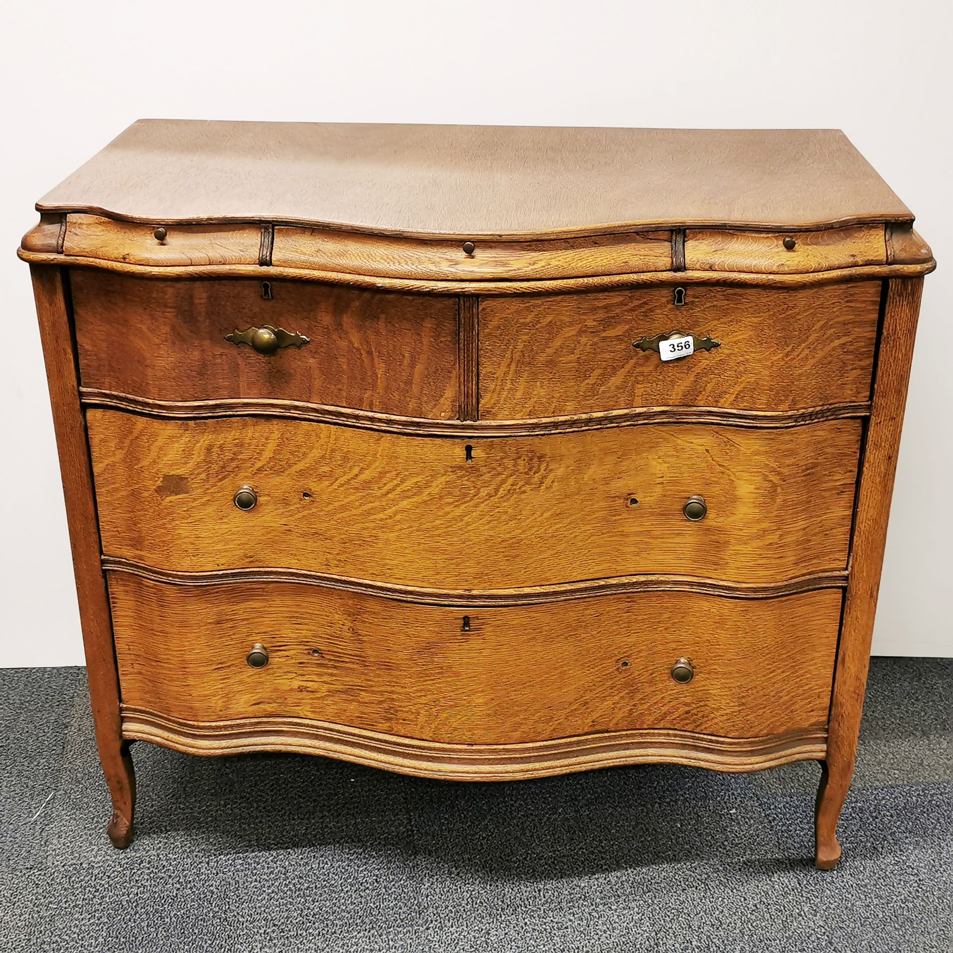 A lovely oak veneered serpentine fronted seven drawer chest, 102 x 56 x 93cm.