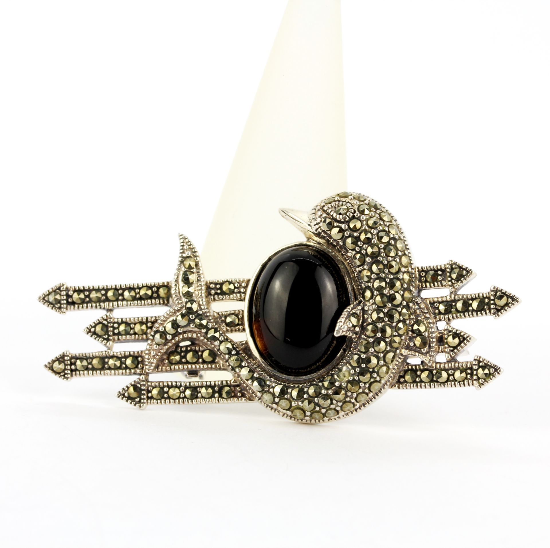 A large 925 silver dolphin brooch set with marcasite and an oval cabochon tourmaline, L. 6cm.