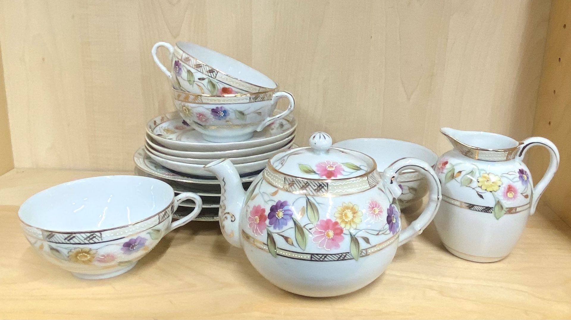 A 1920's Japanese hand painted porcelain four setting tea set.