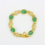 A yellow metal (tested gold) bracelet set with oval cabochon jade, L. 19cm.