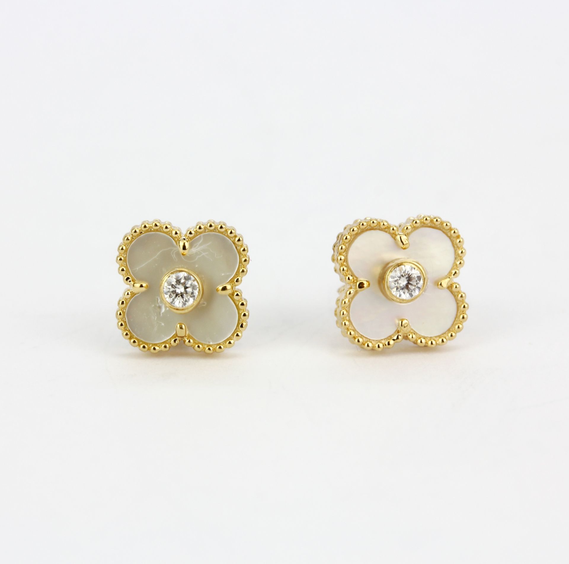 A pair of 18ct yellow gold (stamped 18K) stud earrings set with mother of pearl and a diamond, L.