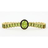 An 18ct yellow gold (stamped 18K) and enamelled bracelet set with oval cut peridot, centre peridot