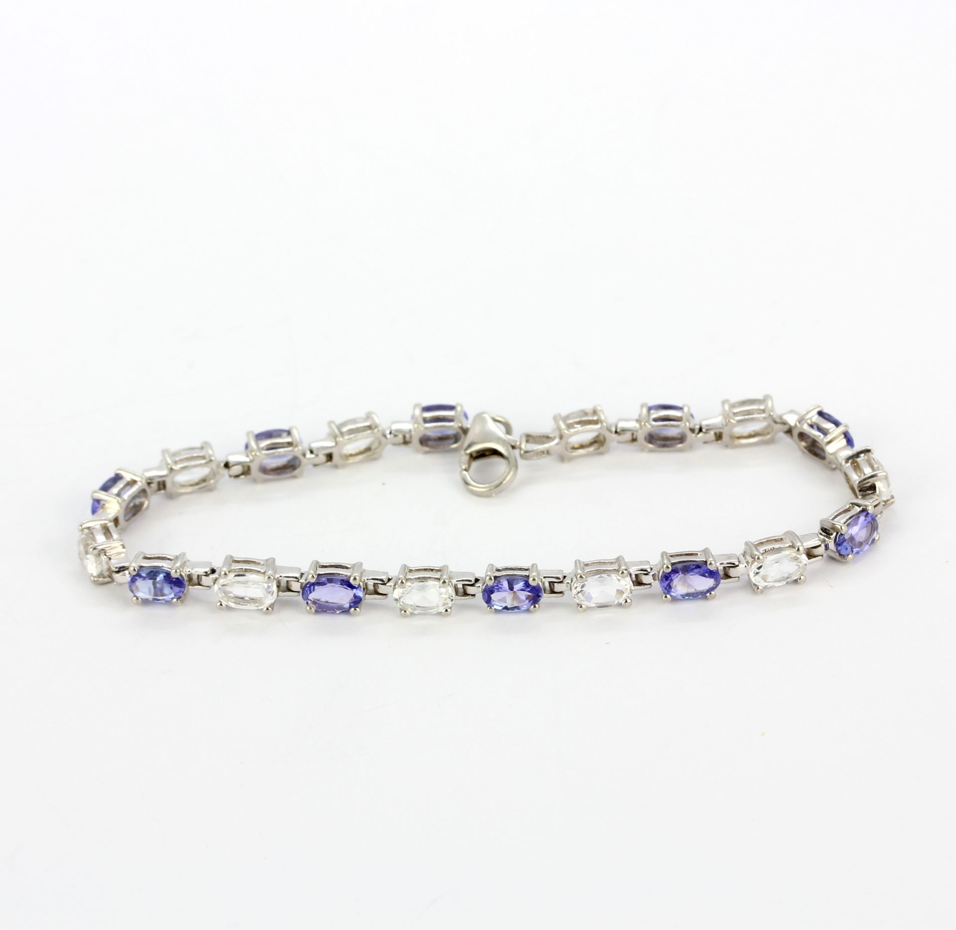 A 925 silver bracelet set with oval cut tanzanites and white topaz, L. 18.5cm.