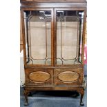 A mid 20th Century oak display cabinet with glass shelves and ball and claw feet, a few small cracks