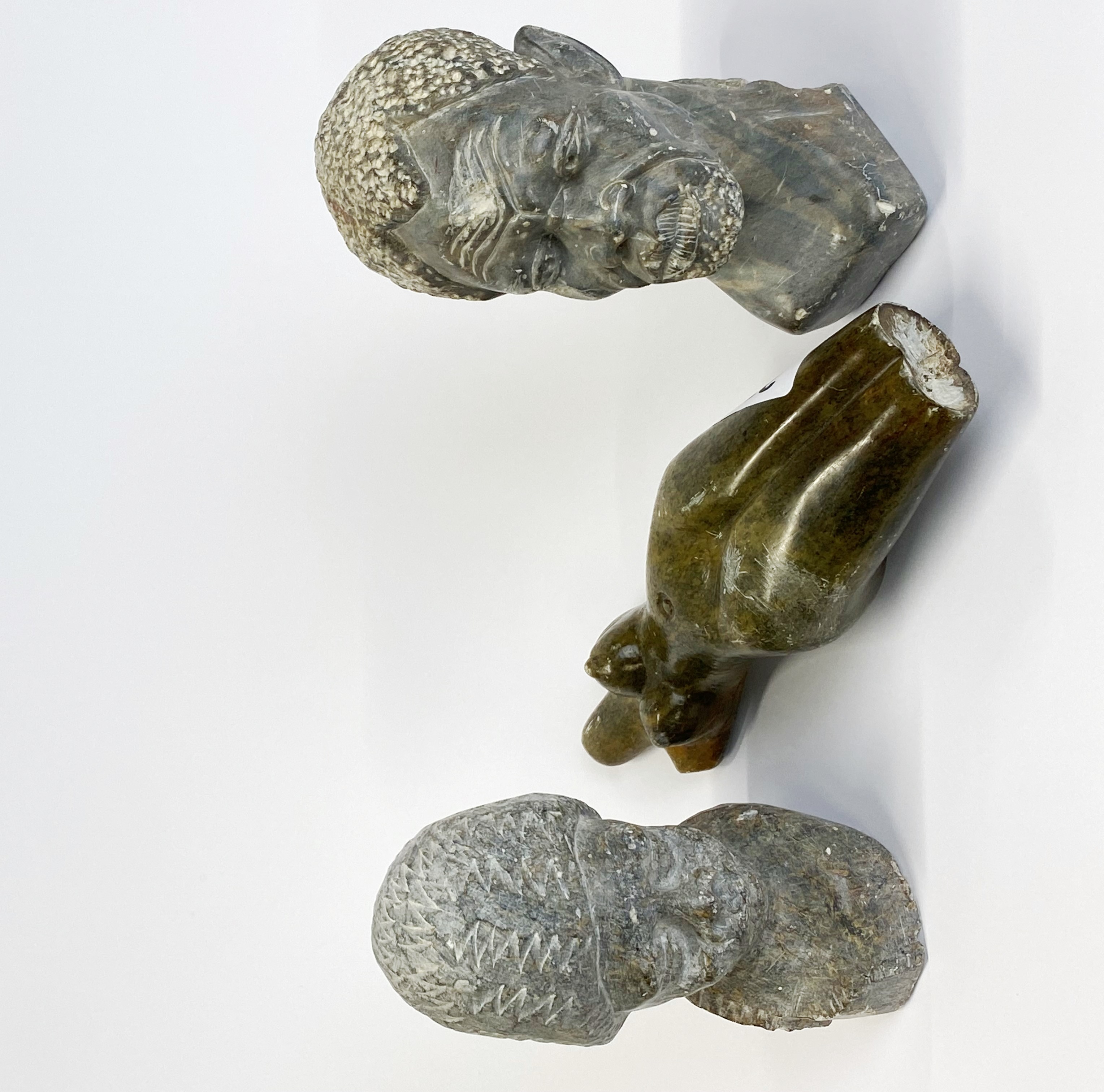 Three carved Zimbabwe soapstone figures, longest L. 20cm.