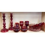 A group of Bohemian etched ruby glass items including a pair of candlesticks, H. 29cm.