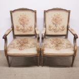 A pair of French painted and gilt salon style armchairs.
