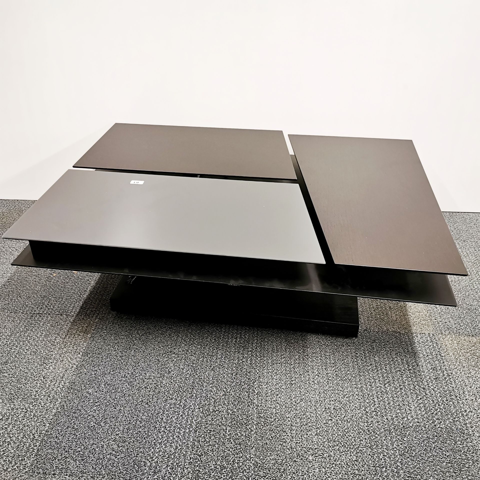 An unusual contemporary designer coffee table in dark cherry and glass with three sections, two