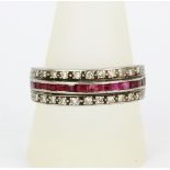 A white metal palladium ring set with rubies and diamonds, (U). Slight bend to shank.
