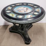 A large circular bronze and black slate table with inset with Sevres style porcelain panels to