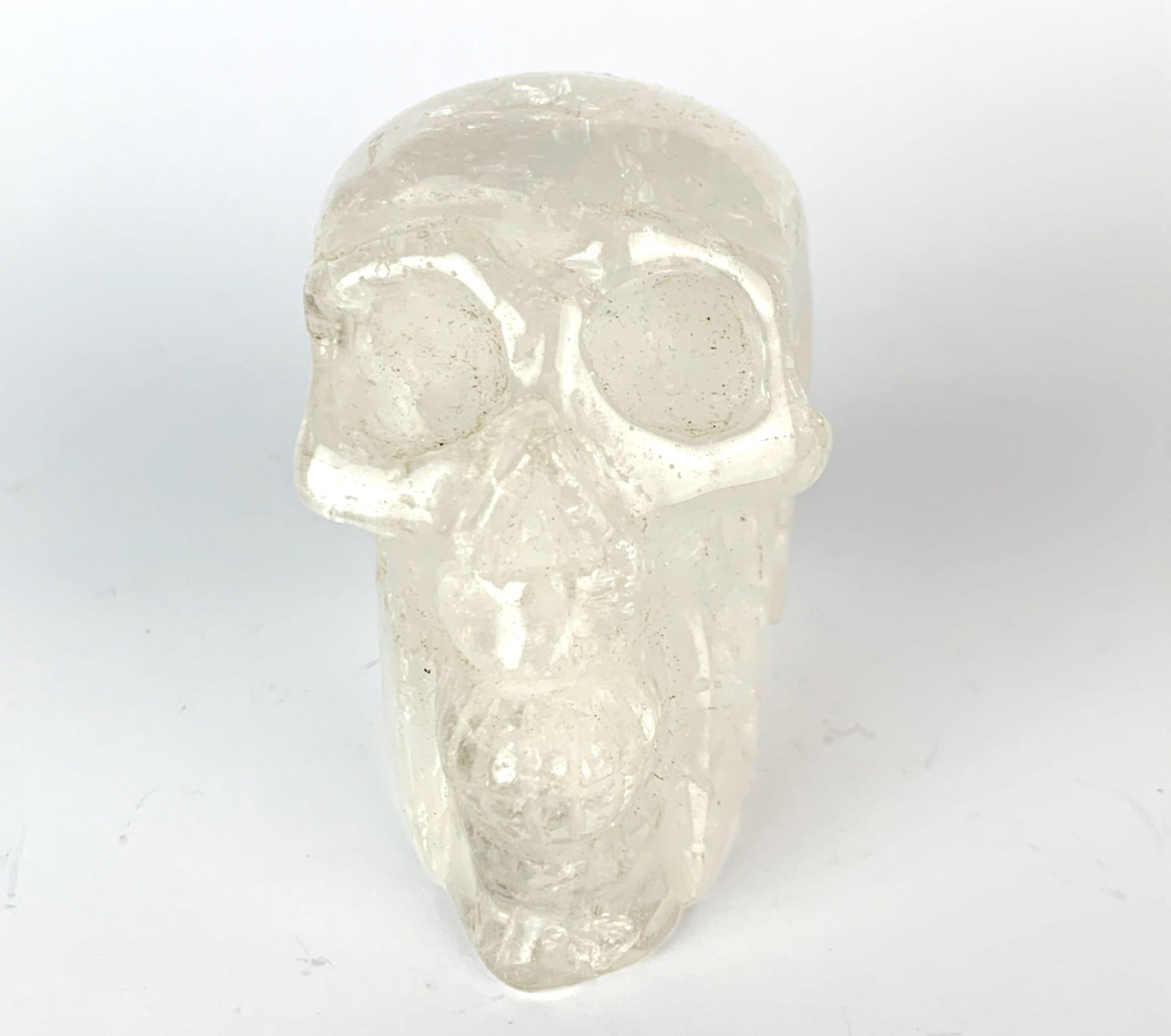 A carved rock crystal skull, H. 7cm.