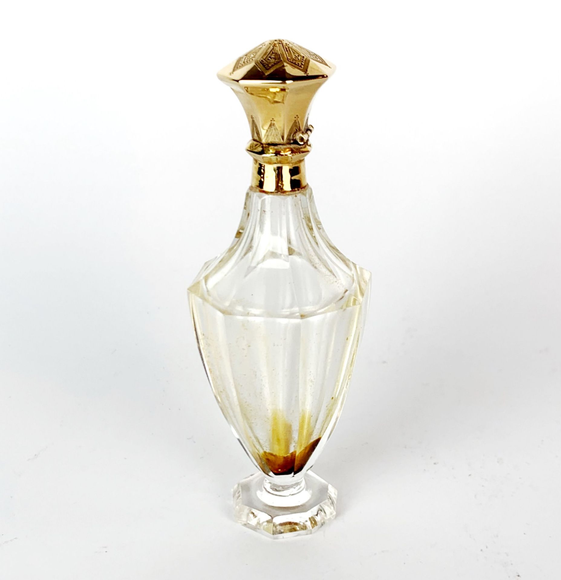 An antique cut glass perfume bottle with 18ct gold top, continental mark and tested, H. 10cm.