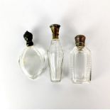 Three antique cut glass and silver topped (tested) perfume bottles, tallest H. 11cm.