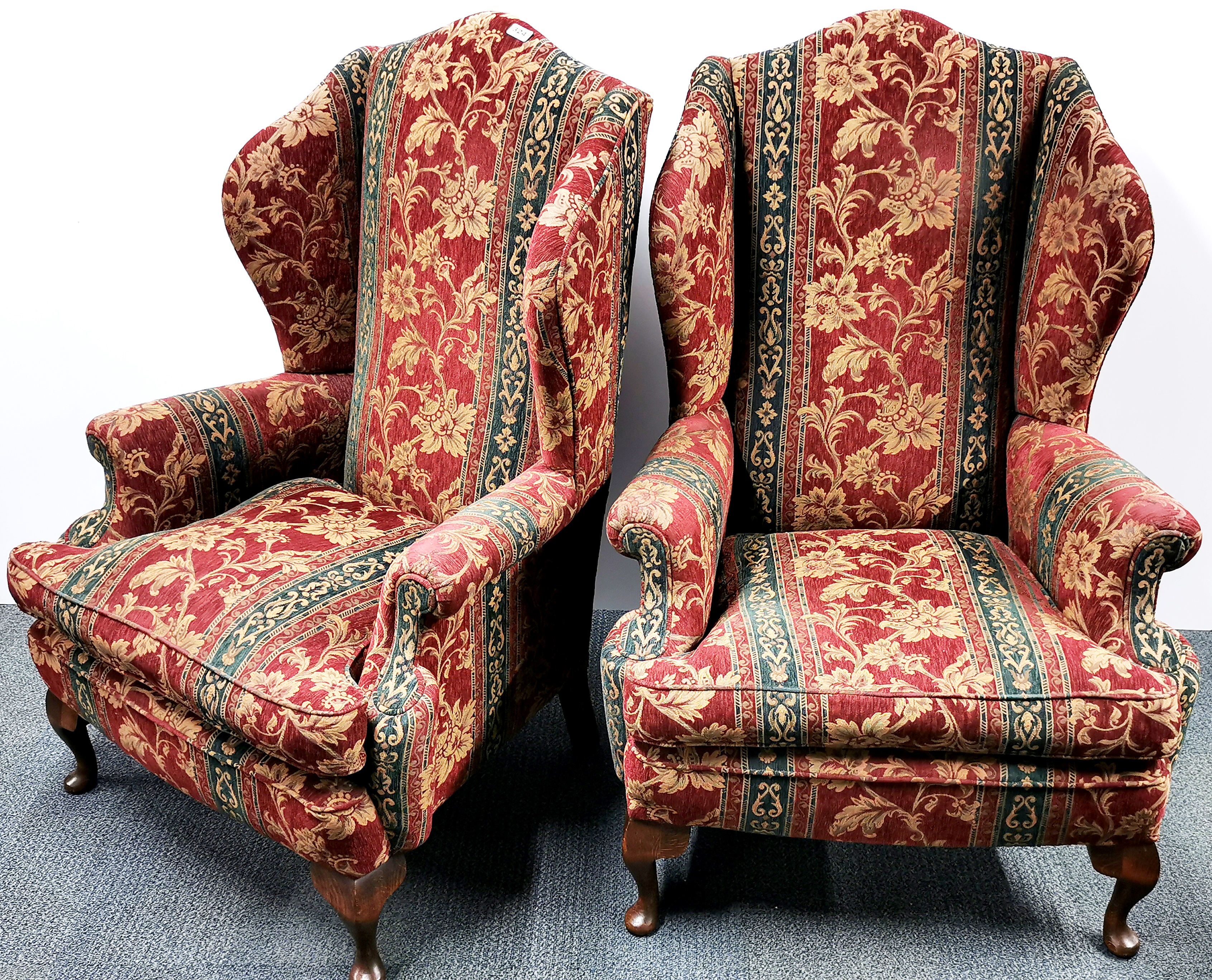 A pair of red and green upholstered wingback armchairs, H. 120cm.