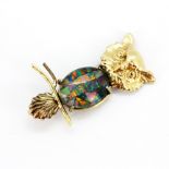 A yellow metal (tested minimum 9ct gold) owl shaped brooch set with a mosaic opal triplet, L.4cm.