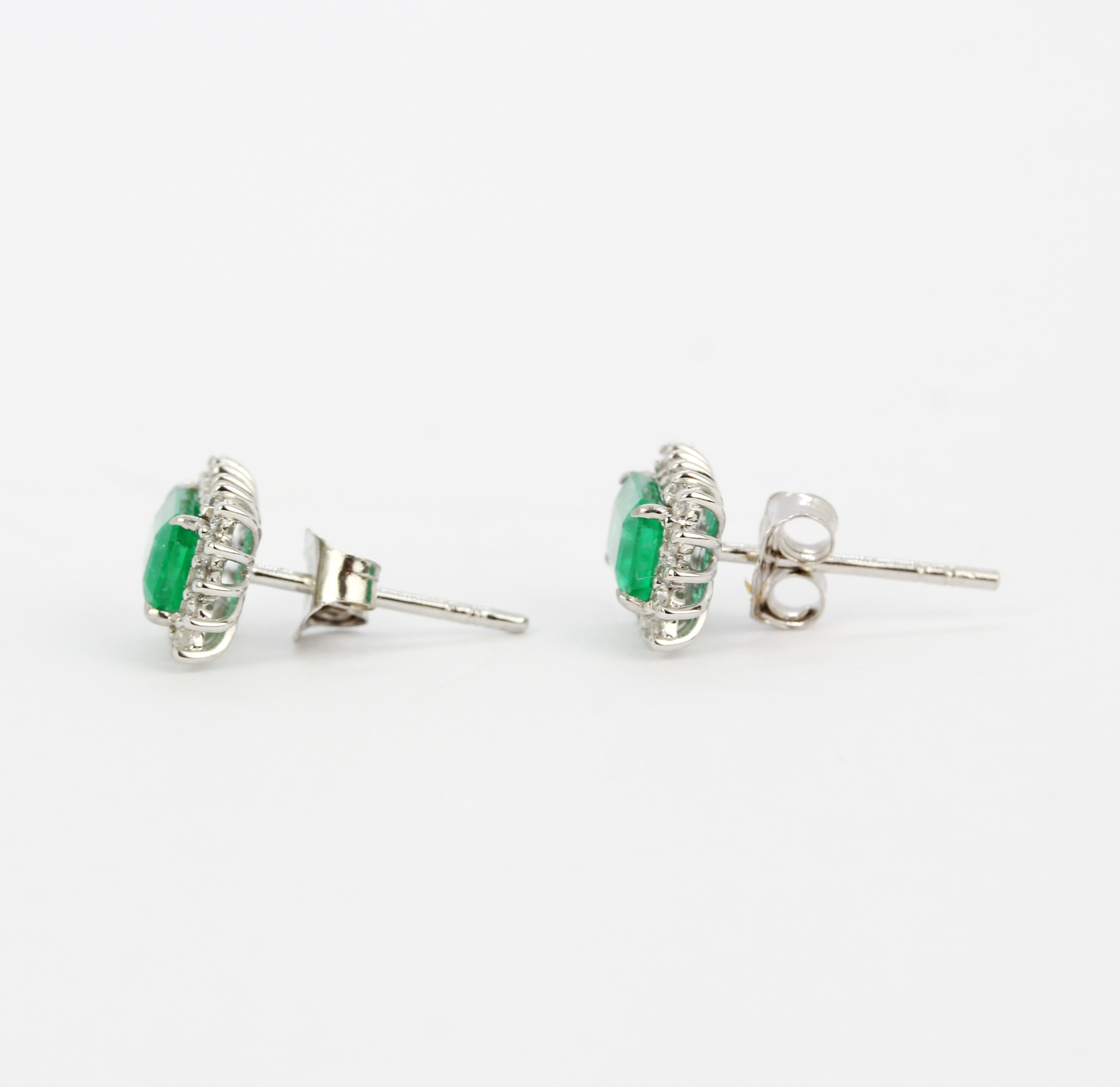 A pair of 18ct white gold stud earrings each set with an emerald cut emerald surrounded by brilliant - Image 4 of 4