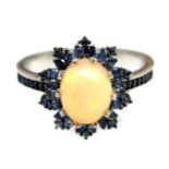 A 925 silver cluster ring set with cabochon cut opals surrounded sapphires and sapphire set