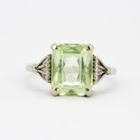 A 10ct white gold (stamped 10K) solitaire ring set with a large emerald cut green stone, stone