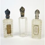 Three cut crystal and silver topped perfume bottles, tallest 10cm.