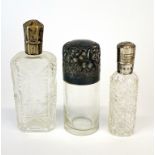 Three silver topped perfume and smelling salts bottles, tallest 9cm.
