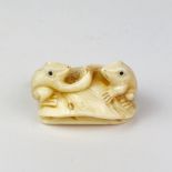 An Oriental carved bone figure of two frogs with obsidian eyes, 4.5 x 4 x 2cm.
