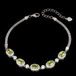 A 925 silver adjustable bracelet set with oval cut peridots and white stones.