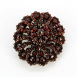 A large Victorian garnet set brooch/pendant, 4 x 3.5cm. Two garnets missing.