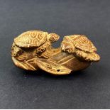 A Japanese signed fruitwood netsuke of two turtles, L. 6cm.