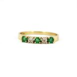 A 14ct yellow gold half eternity ring set with round cut emeralds and diamonds, (P).