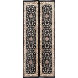 A pair of black ground contemporary rugs, 67 x 300cm.
