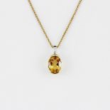 A hallmarked 9ct yellow gold pendant set with an oval cut citrine and a tapered baguette diamond